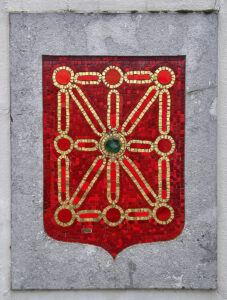 Le blason de Basse-Navarre reprend les armoiries du Royaume de Navarre. Un écu rouge porte 7 châines et une émeraude à son centre.