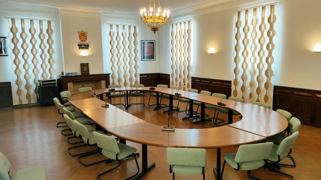 La salle du conseil municipal se situe à l'étage du bâtiment de la mairie. Il ets accessible depuis la place Charles de Gaulle. 